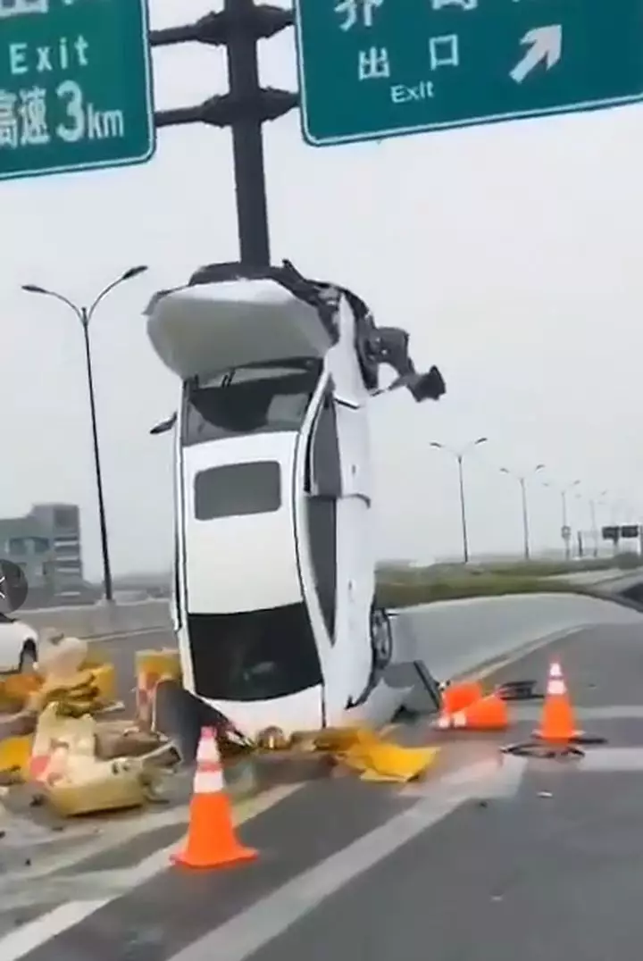 杭州高架一白色轿车垂直开上标志杆怎么上去的呢?