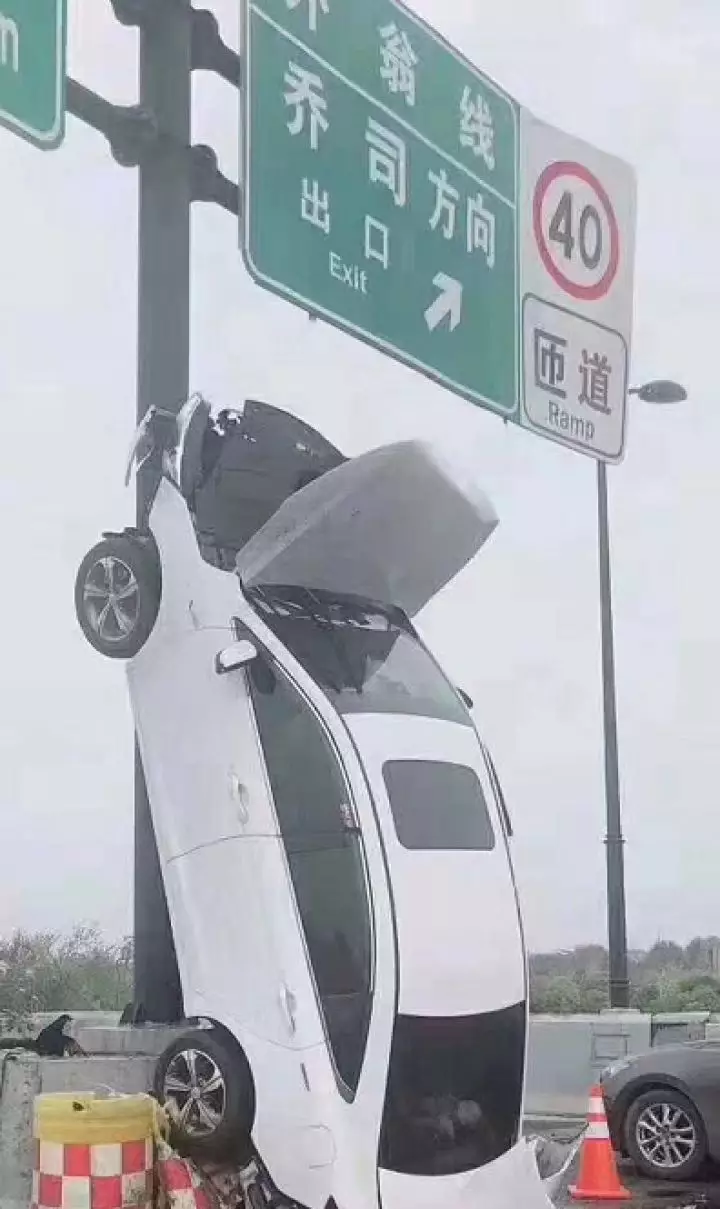 杭州高架一白色轿车垂直开上标志杆怎么上去的呢?