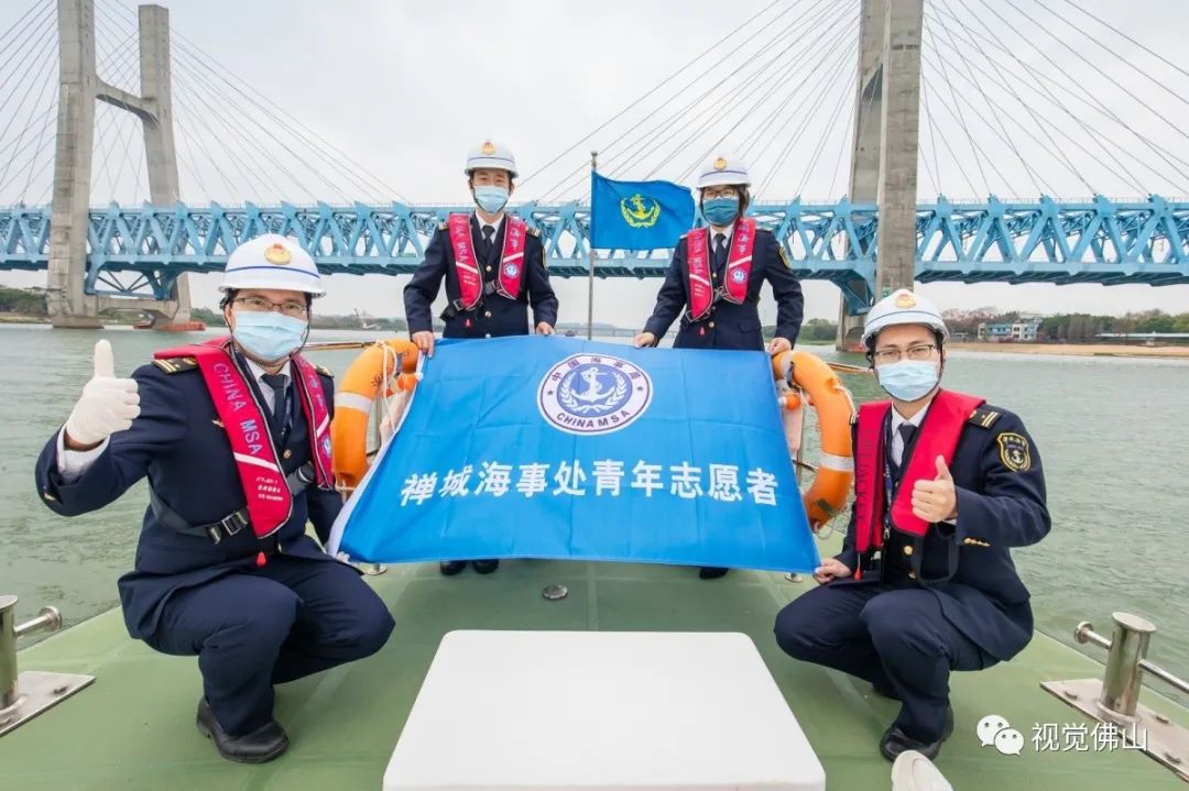 2020年3月5日是学雷锋纪念日,佛山海事局的志愿者们登上船舶慰问船员并为船员送上防疫口罩,当海事船航行至贵广铁路桥时,禅城海事处的青年志愿者们合影留念。佛山日报记者王澍摄.jpg
