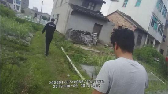 当天早上6时左右,男子(穿T恤者)被民警带回派出所做调查。