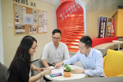 梁鉴坤(右)和唐震宇正在与香港创业青年梁女士签订入驻合同。