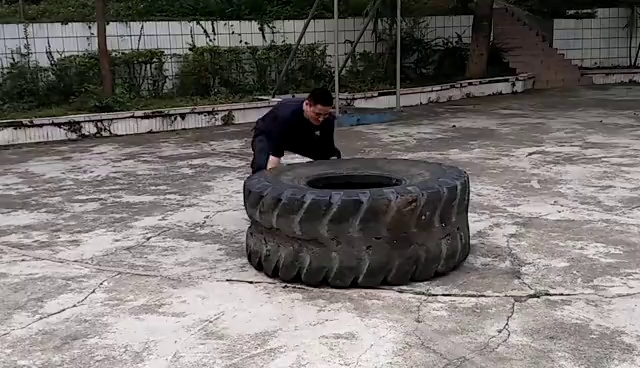 袁家林正在搬运100多公斤重的轮胎，进行体能训练。