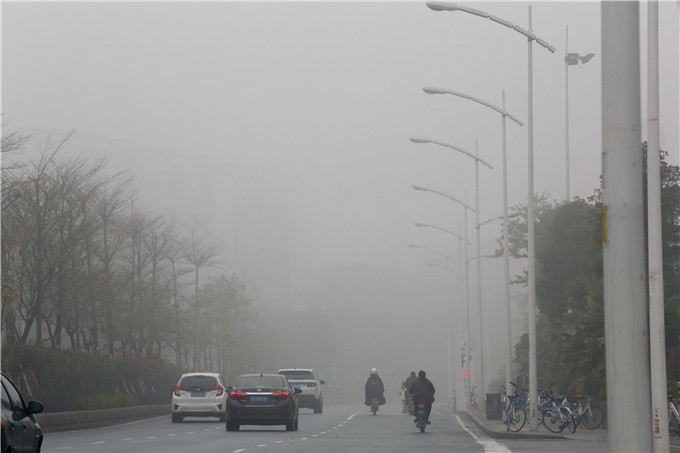 三水区西青大道,雾气中的车辆行驶缓慢。 佛山日报记者 陈浩森摄
