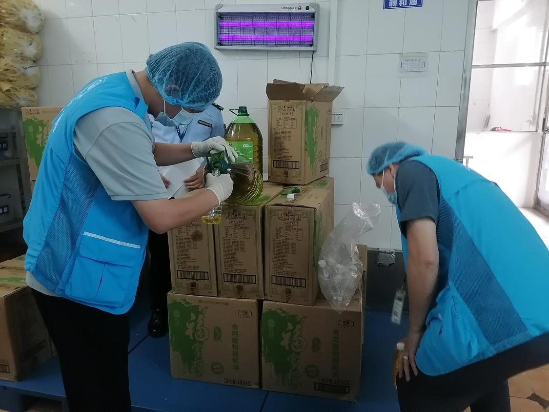 第三方检测人员在对学校食用油进行抽样.jpg