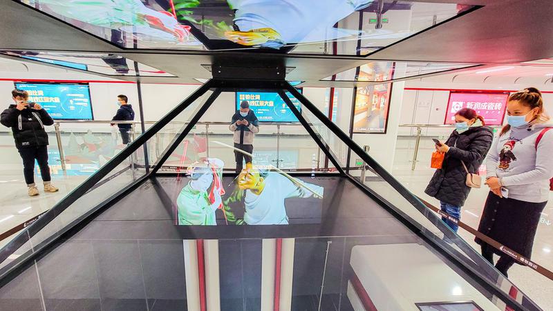 市民在2号线石湾站观看3D博物馆。利用3D全息投影,以“流动的博物馆”作为主题,展示各种陶瓷艺术品。/佛山日报记者周春摄