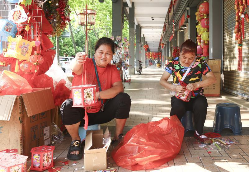 9月21日,禅城松风路富兴纸业门口,两位店员手工制作灯笼。/佛山日报摄影俱乐部成欲晓摄