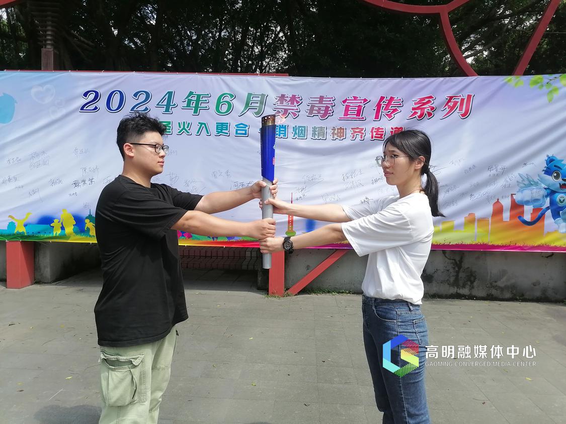 禁毒人员把火炬传递到村民代表手中。.jpg