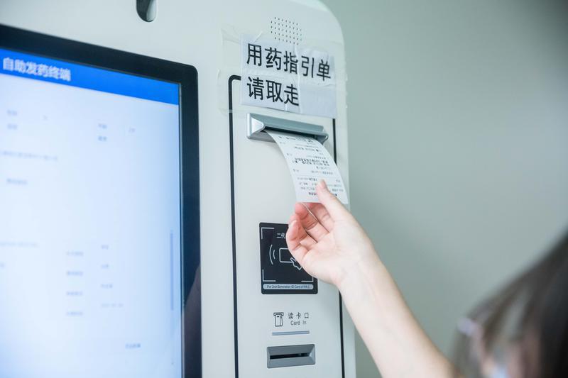扫码之后，可以取走用药指引单，核对相关药品信息。/佛山日报记者王伟楠摄