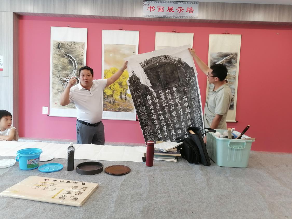 李美征在向小朋友展示碑文书法。.jpg