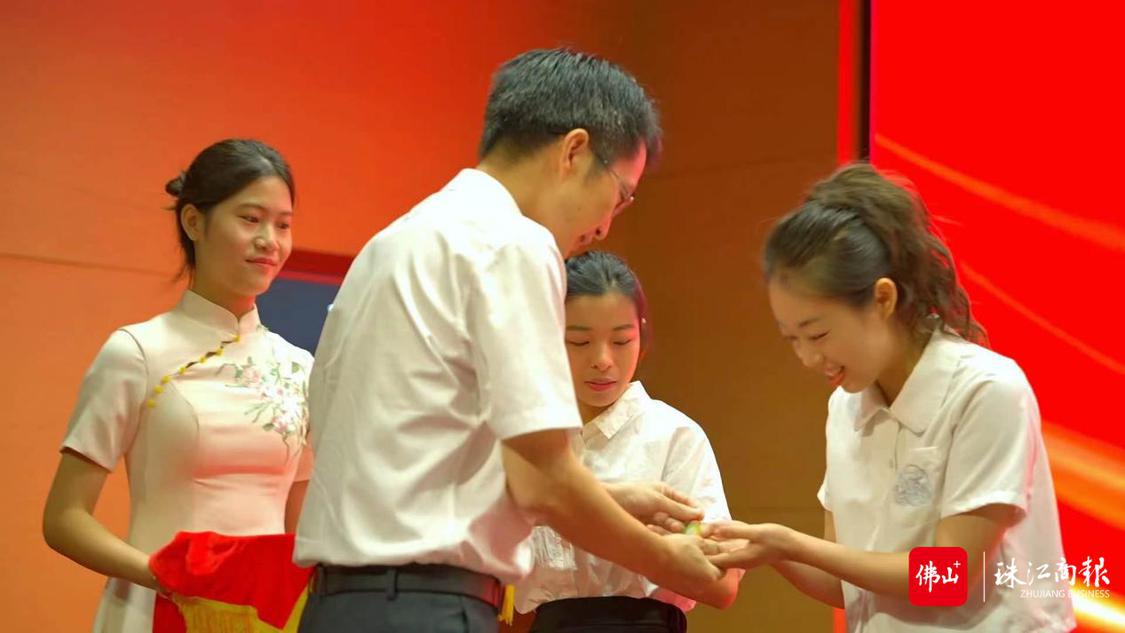 顺德区教育副局长刘进华为新教师代表们颁发入职徽章。.png