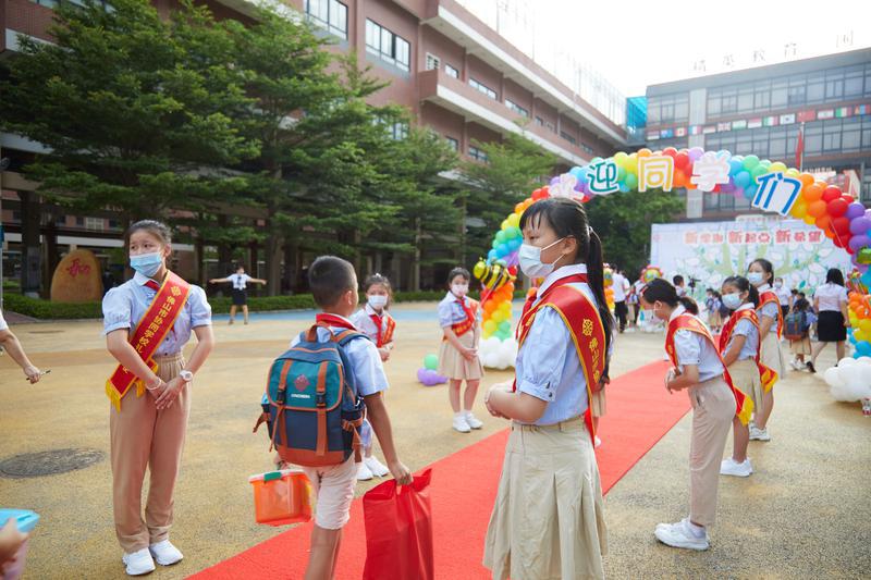 协同学校礼仪大使在校门口迎接同学返校。/佛山日报记者吕润致摄