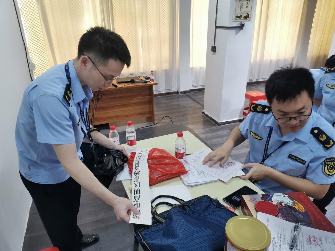 区市场监管人员在进行执法查检.jpg