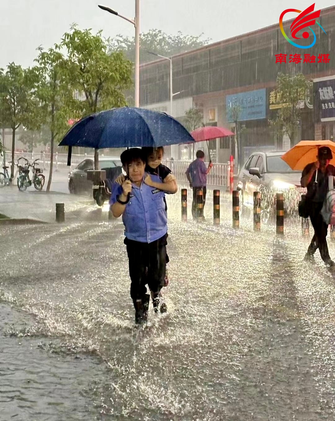 早上大雨，民警在桂城灯湖第六小学背着孩子进学校。网友供图.JPG