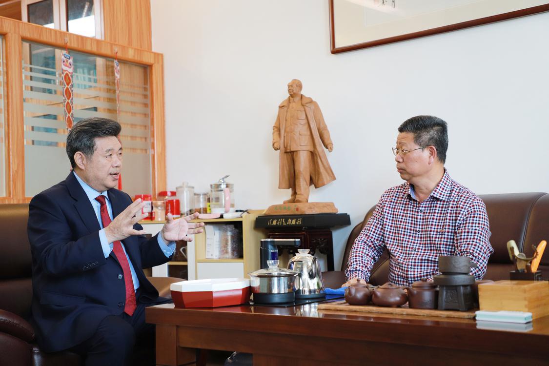 郑宏彪（左）与狮山实验学校校长许贤苏交流红色文化教育经验。.jpg