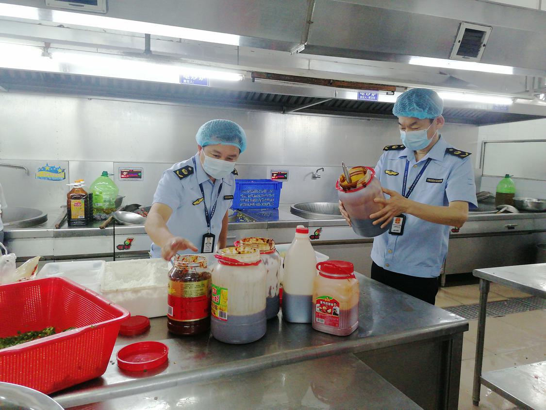 市场监管人员在学校厨房检查酱料食品.jpg