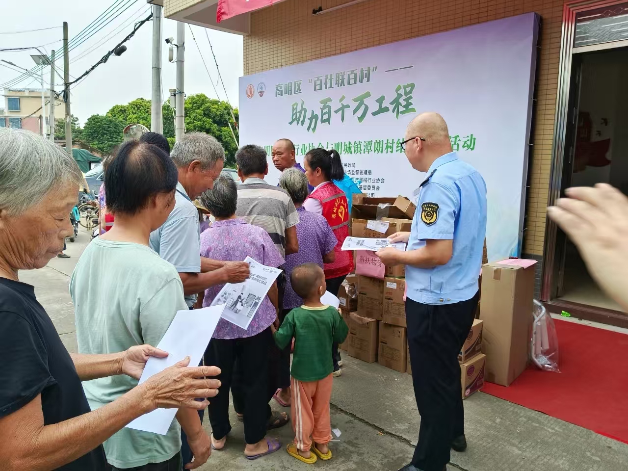 工作人员向村民发放“药械化”宣传资料。.jpg