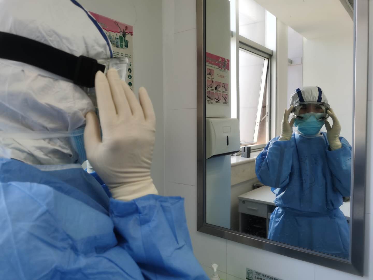 佛山医疗队队员对着镜子调整护目镜。