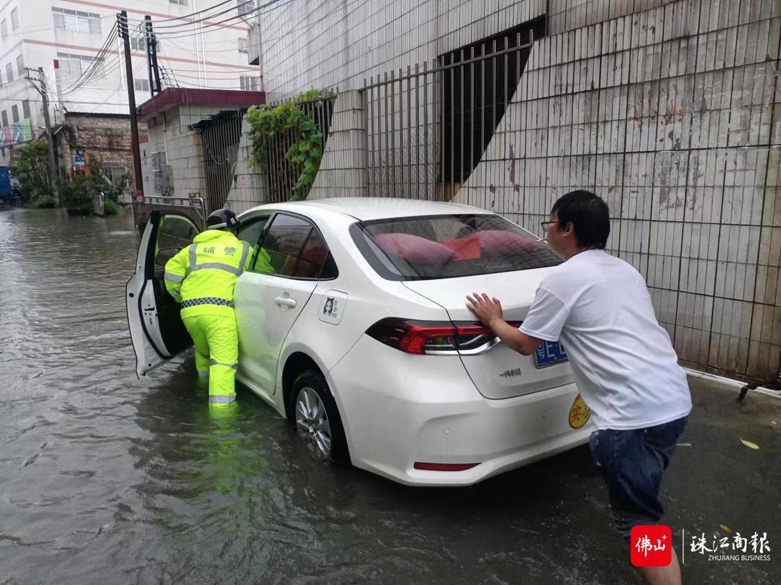 车辆在积水道路抛锚,警辅人员协助车主推车。.jpg