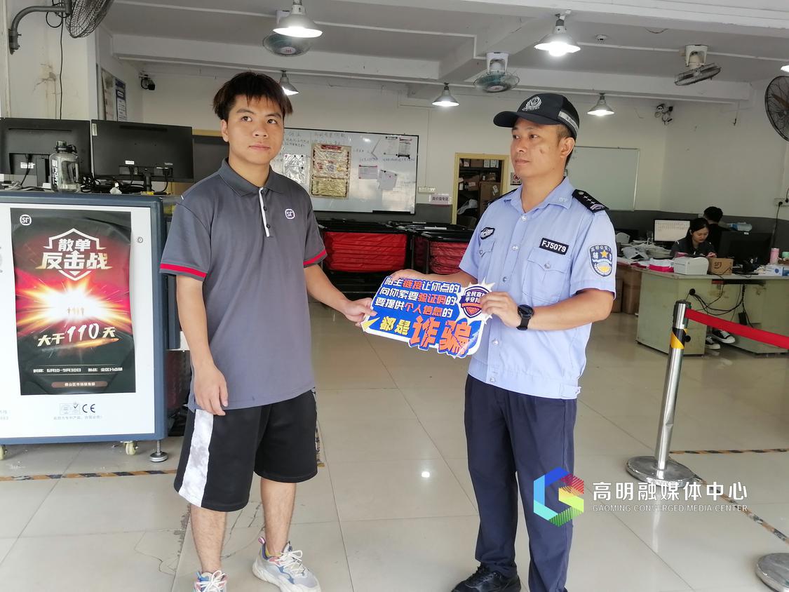 公安人把防诈骗标识牌交给快递小哥本哈哥。.jpg