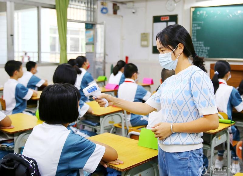 9月1日开学当日,荣山中学防疫工作非常到位,中午午饭后午休前,老师给学生量体温。/佛山日报摄影俱乐部何文莉摄