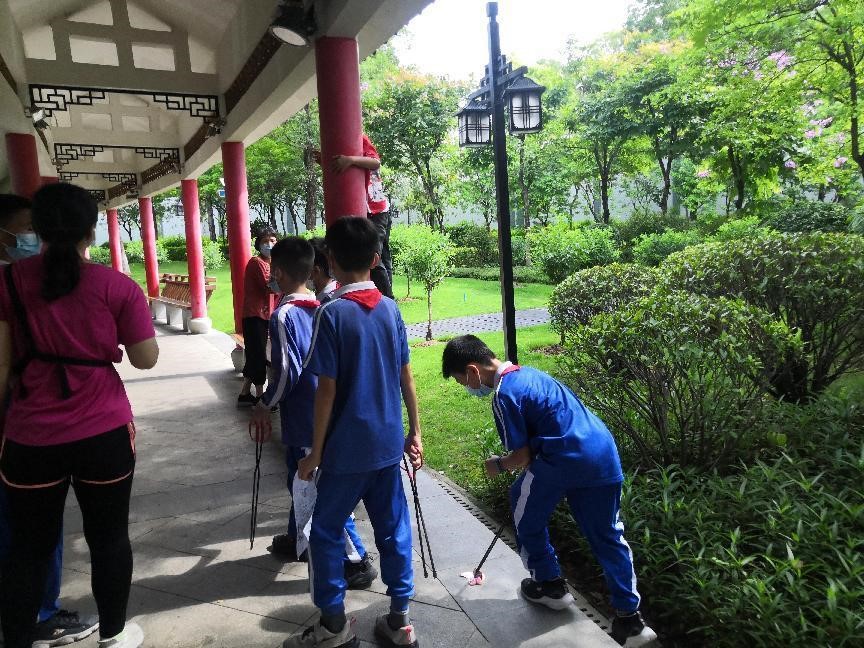 在巡河过程中一边捡拾路面垃圾,一边劝阻攀爬的孩子.jpg