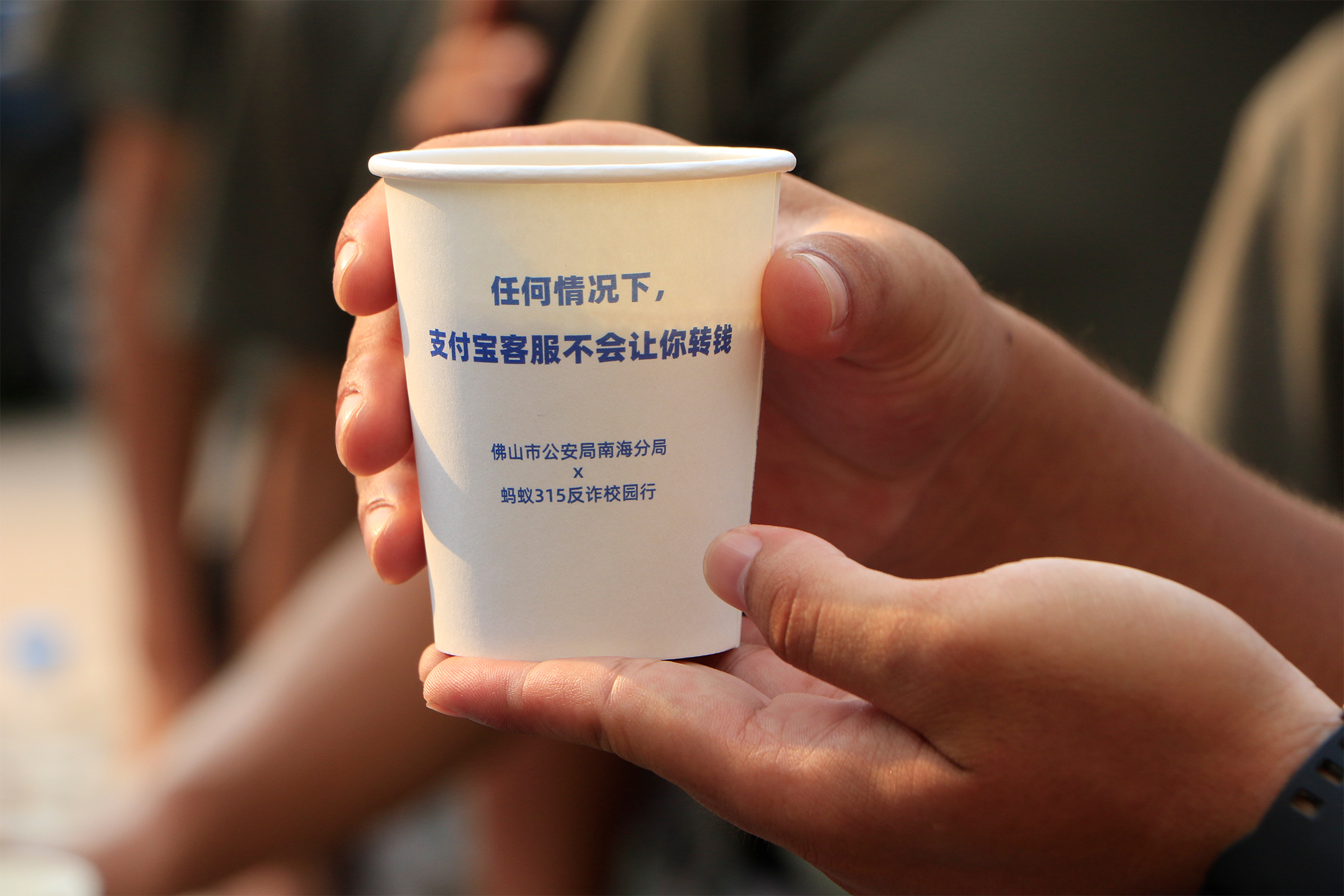 1.警方因地制宜,将反诈标语印在凉茶上派发给师生和家长。通讯员供图