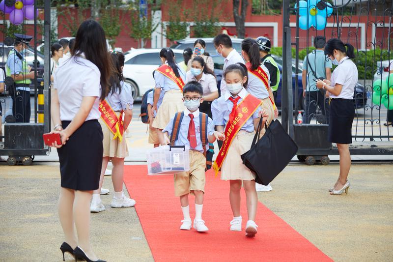 协同学校礼仪大使迎接同学返校。/佛山日报记者吕润致摄