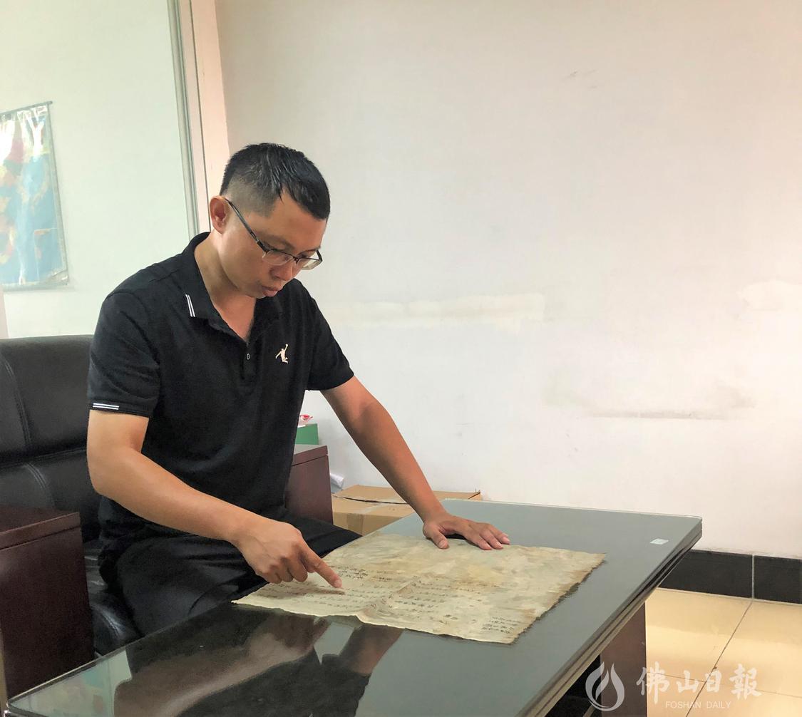 区伟健向记者介绍载有庆洲古窦的地契。.jpg