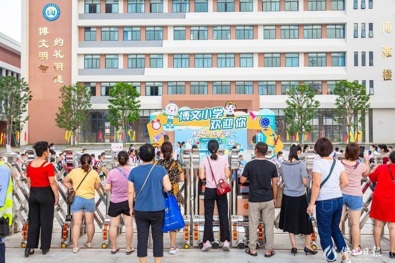 9月1日,三水区云东海街道博文小学新学期开学首日,送孩子上学的家长们在校门口看着孩子被老师带进班级。/佛山日报记者王澍摄