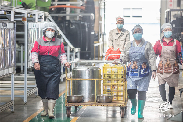长春富维安道拓汽车饰件系统有限公司佛山分公司后勤人员将饭菜推至车间,统一提供给车间工人。实习生廖明璨摄
