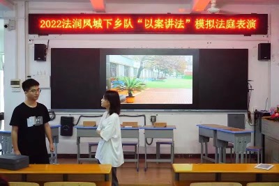 实践队员在为学生进行“以案讲法”模拟法庭表演。.jpg
