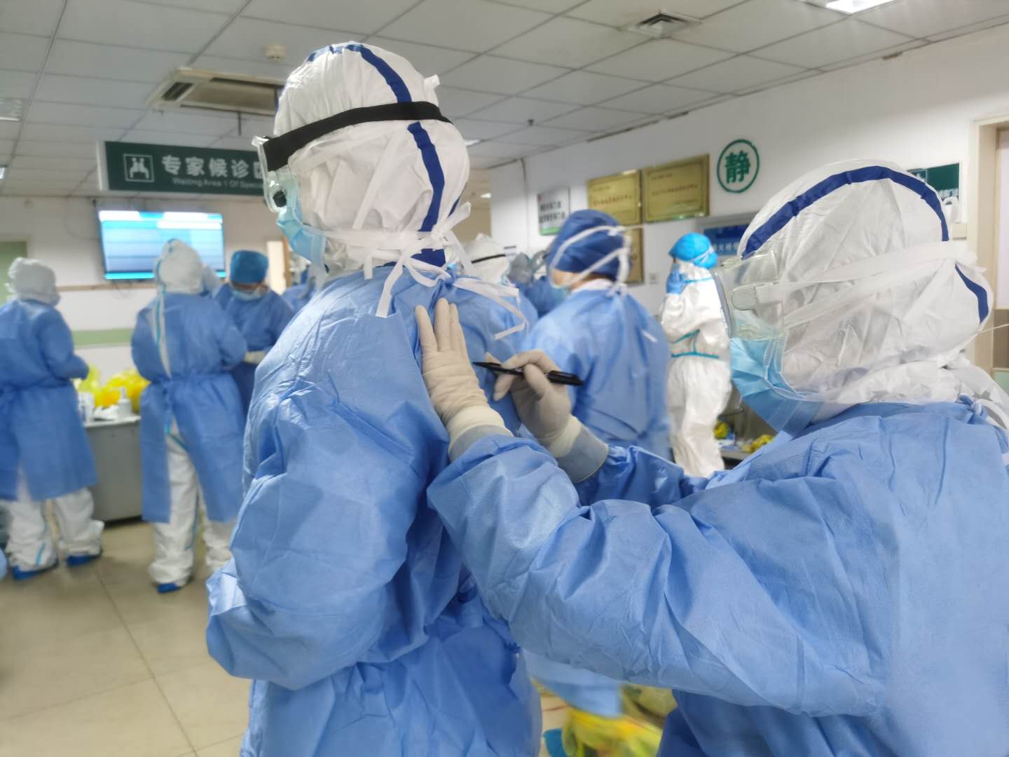 佛山医疗队队员们互相帮忙在防护服上写上各自的姓名。