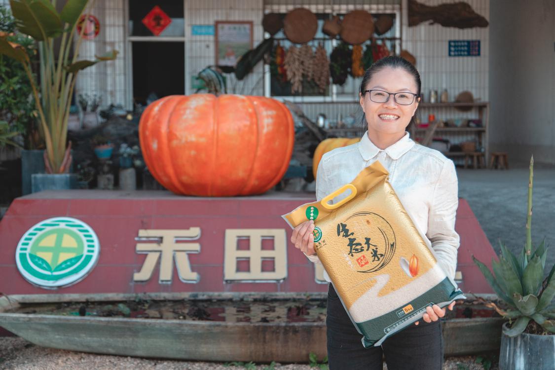 此前,禾田农业创办人李伟玲在更合镇妇联帮助下获得创业小额担保贷款,使公司成功渡过难关。图为李伟玲展示公司出产的生态大米。区妇联供图.jpg