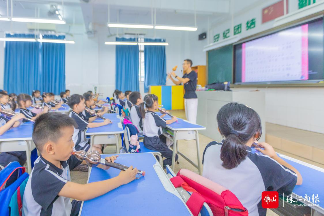 民乐是新圩小学特色校园文化项目。在音乐课堂上，音乐老师正在为同学们讲授葫芦丝吹奏技巧。珠江商报记者周焯杰摄.jpg