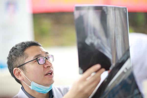 来自广东的医疗专家正在为墨脱群众讲解X光检查结果。佛山日报记者 张弘弢摄
