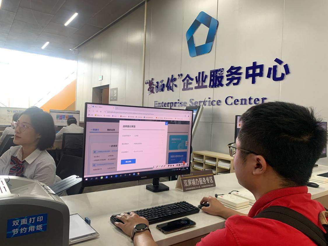 办事人正在体验双屏辅办服务,在导办员指引下完成企业设立申报.png
