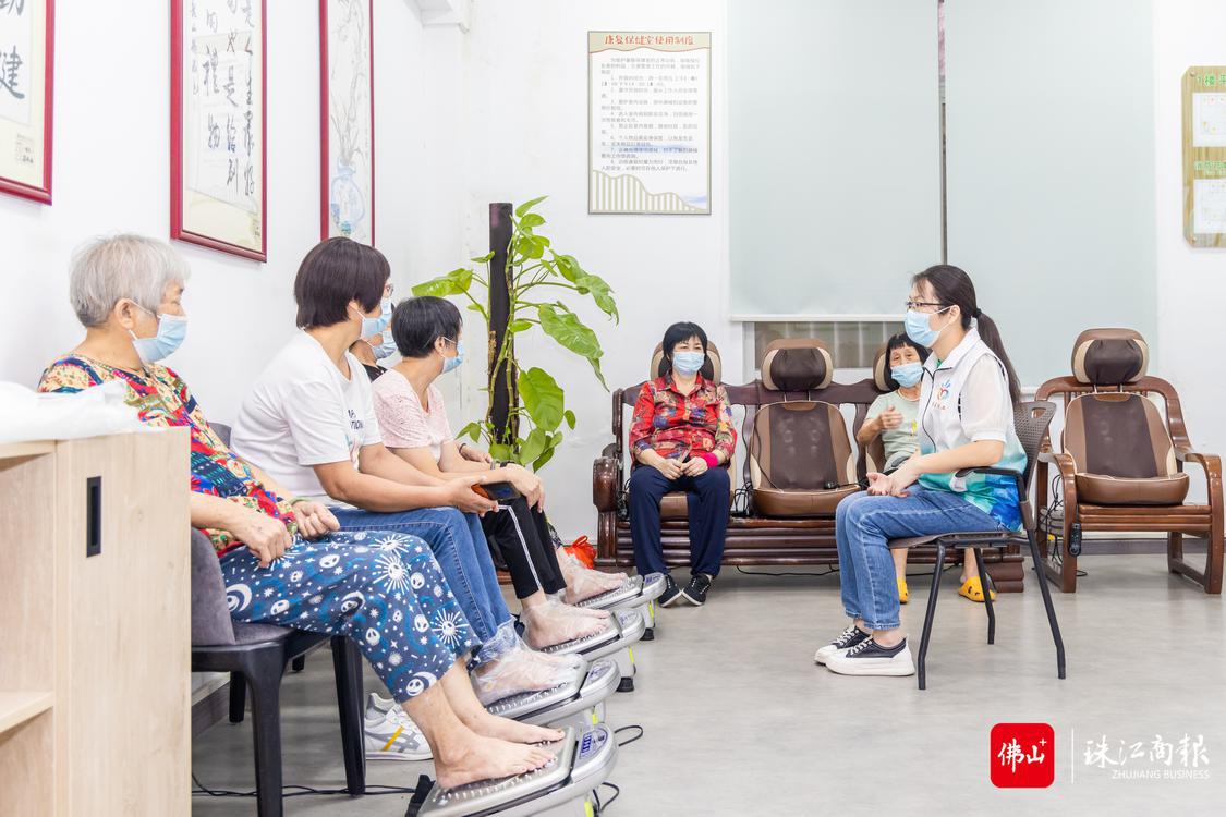 9月5日,尚善社工项目主管覃婉清正在龙江镇龙山长者综合服务中心康复保健室内与体验按摩器械的长者交流。珠江商报记者林安迪摄 (2).jpg