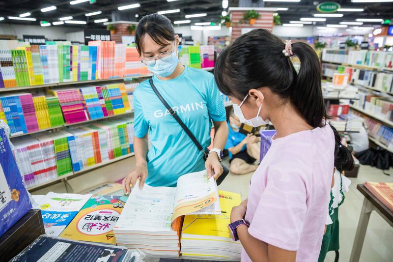 陈村镇东方书城,家长正在与孩子一起挑选教辅书。/佛山日报记者王伟楠摄