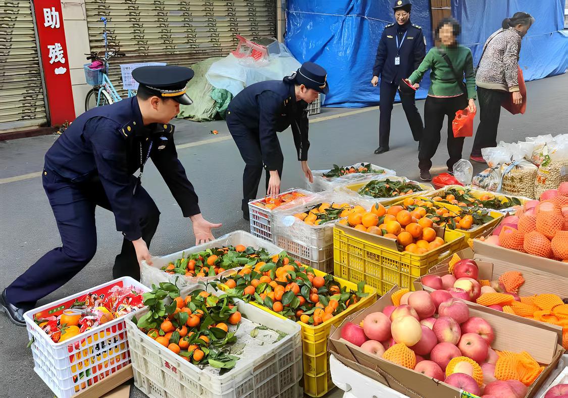 执法队员帮手把超出范围的水果搬进经营区域.jpg