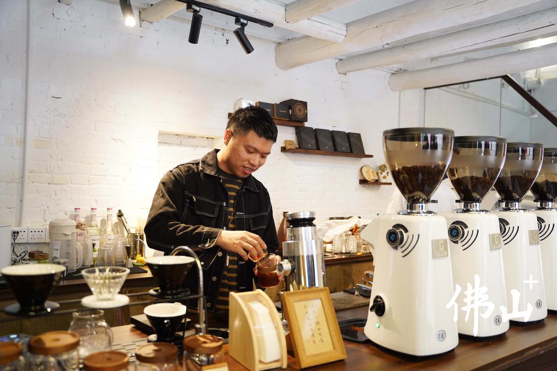 位于白坭文创古镇西江院子内，具有岭南古建筑风的泥·COFFEE，店主正在调制一杯手磨咖啡。2.JPG