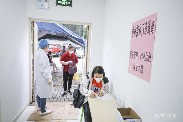 预防接种门诊通道,市民正在进行流行病学史登记。/王伟楠摄