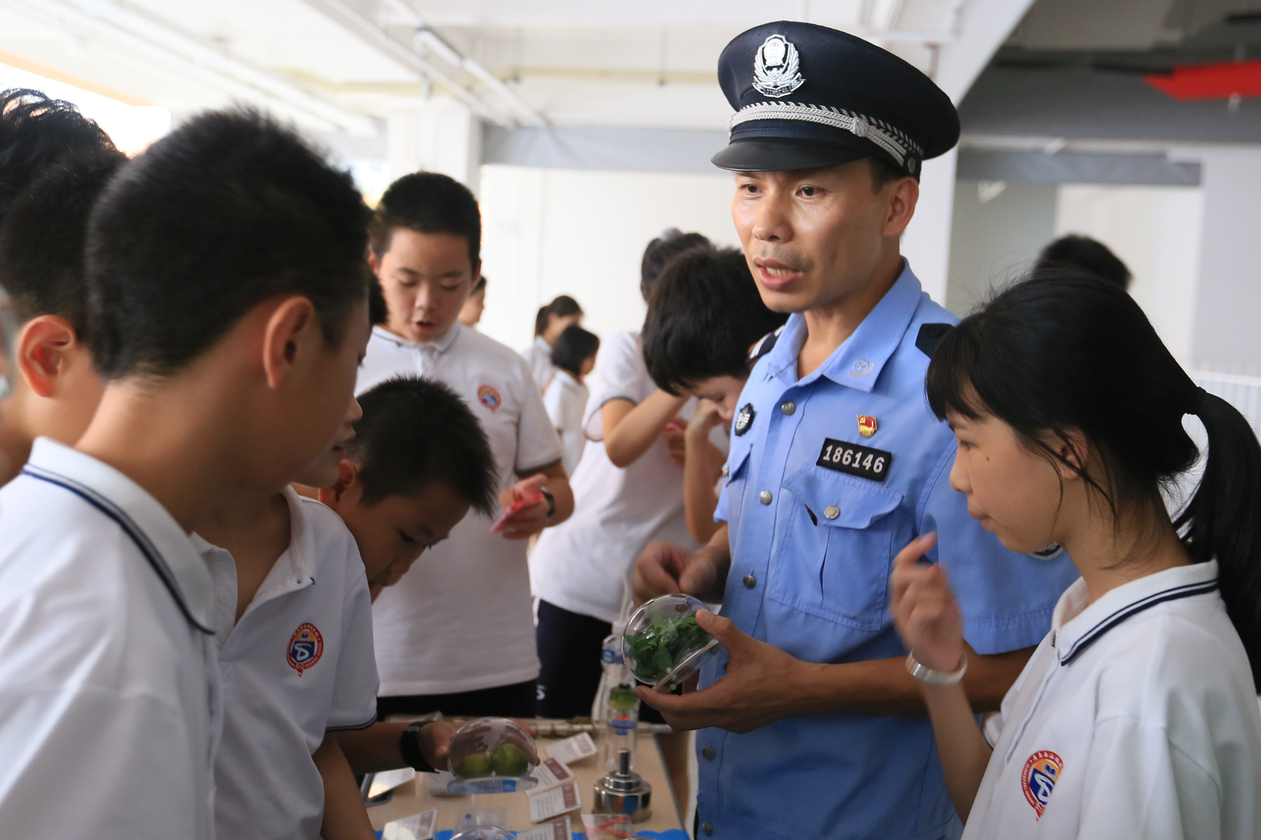 民警陈景麟拿着毒品模型向学生讲解禁毒知识。