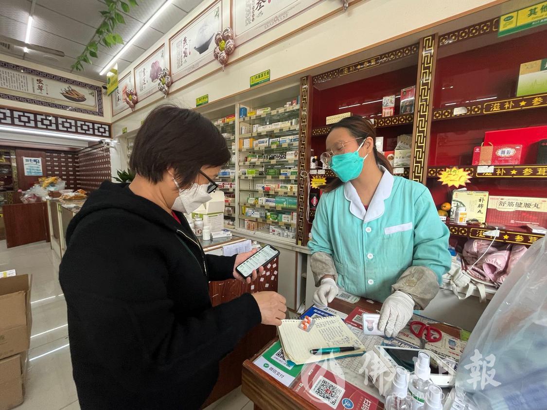 今天(12月21日)下午,市民正在大恒仁药店沧江二路店领取布洛芬缓释胶囊。佛山日报记者陈嘉懿摄.jpg