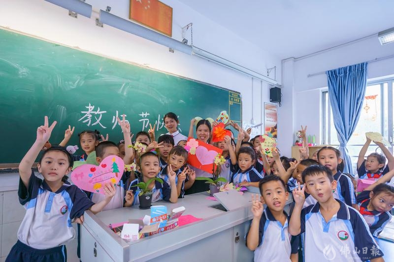 师情话意,欢声笑语,佛山禅城区惠景小学,二年一班的同学们纷纷地将精心自制的贺卡献给老师后,簇拥老师合照留影。/佛山日报摄影俱乐部张秀丽摄