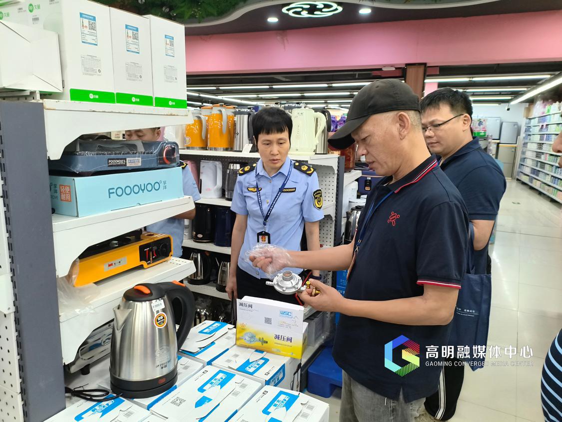 执法人员在查看灶具的相关资料说明书。.jpg