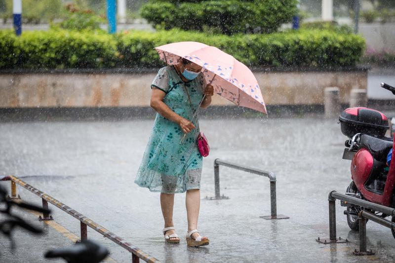 顺德陈村镇顺联广场,一名阿姨正撑着雨伞艰难走在大雨中。/佛山日报记者王伟楠摄