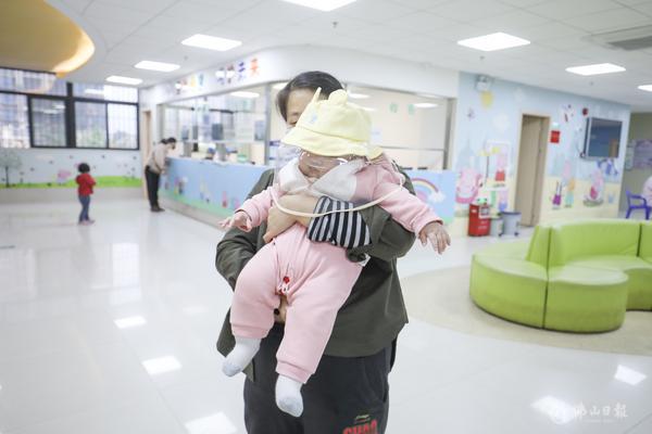现场一家长为孩子戴上儿童防护帽,因其孩子不愿戴口罩,只能如此“硬核”进行保护。/王伟楠摄