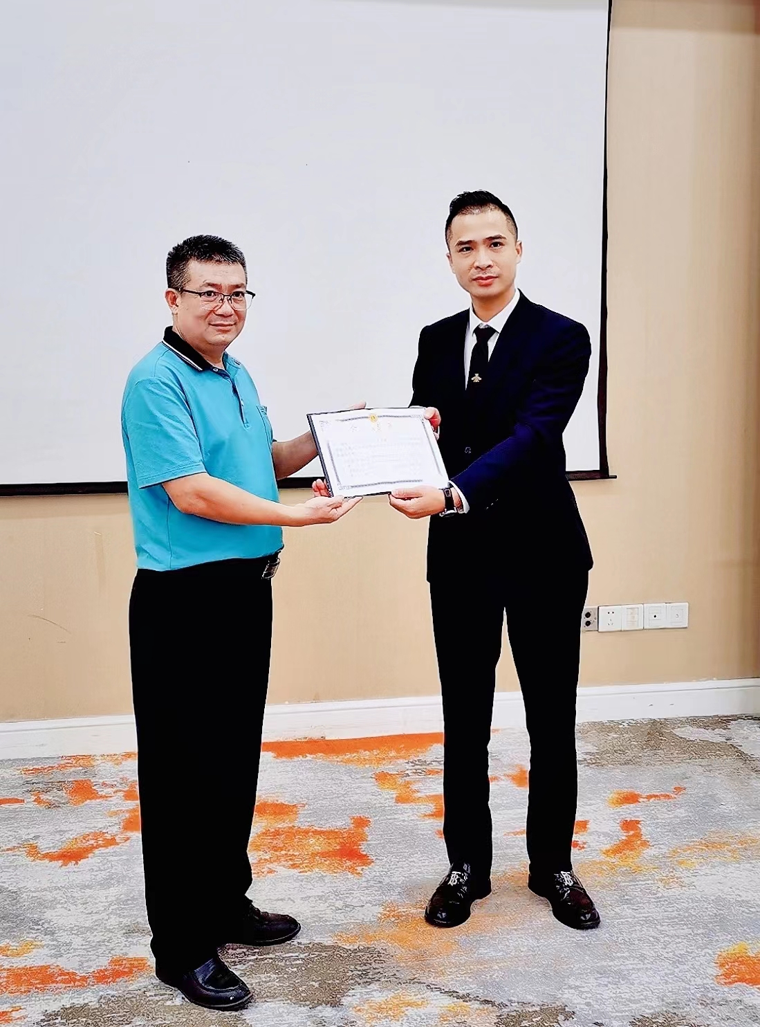 高明区总工会常务副主席陈云健将《工会法人资格证书》送到碧桂园凤凰酒店工会主席麦海宏手中,这是高明区首家企业体验到足不出户获得《工会法人资格证书》的便利。总工会供图.jpg