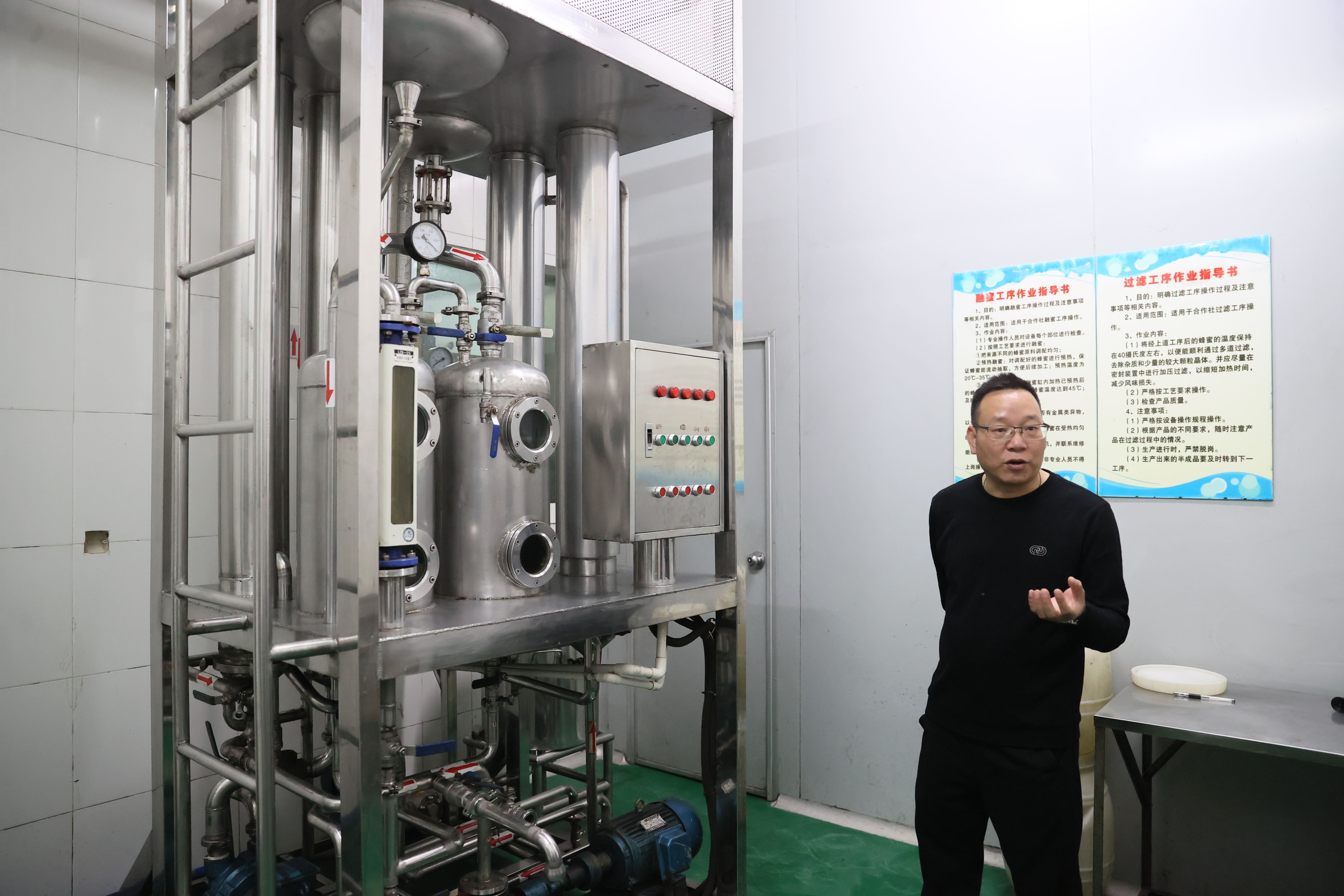 龙门县供销合作联社养蜂研究所副所长钟国平在介绍蜂蜜初加工过程。 龙门县供销合作联社养蜂研究所副所长钟国平在介绍蜂蜜初加工过程。