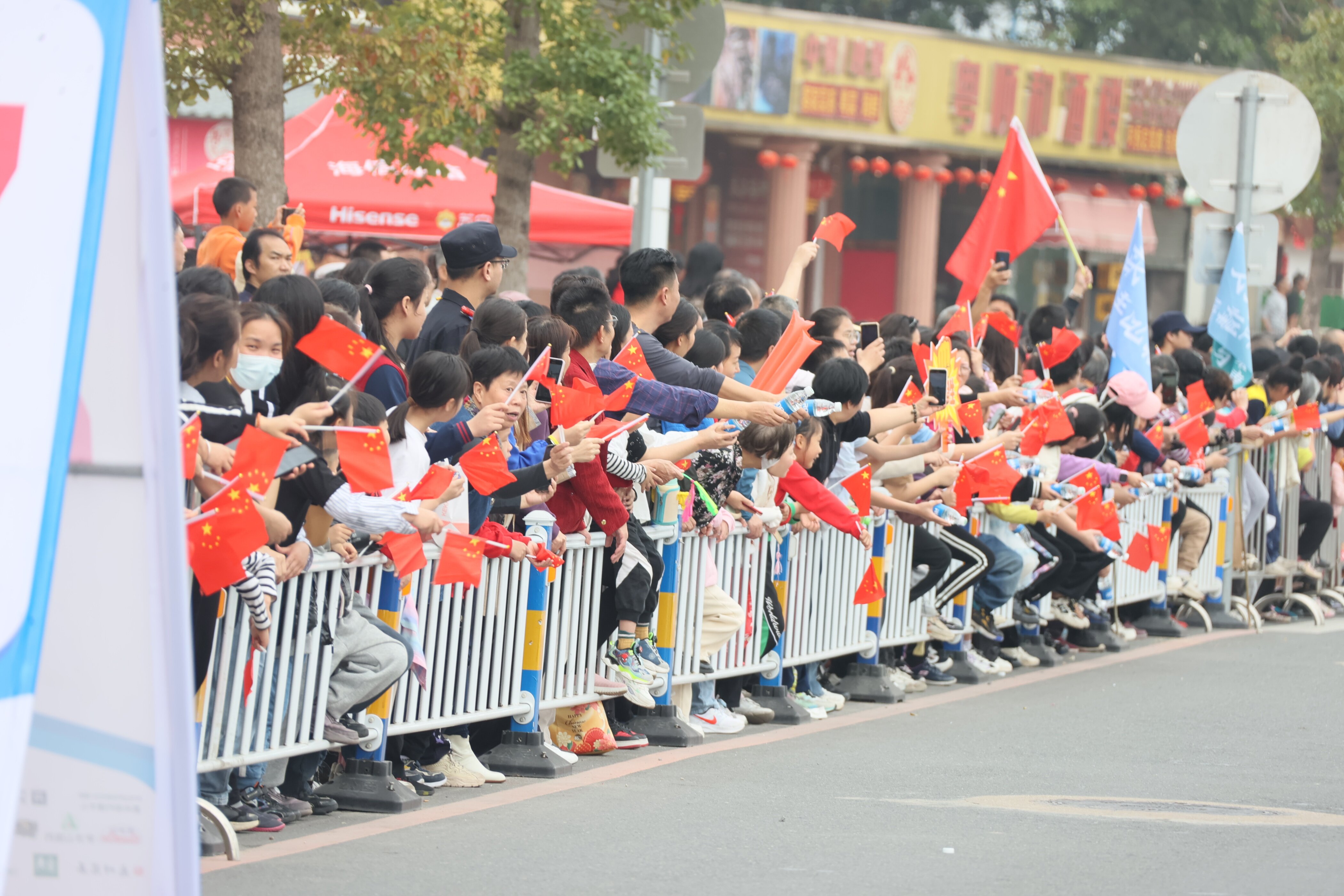 市民手持国旗为选手加油助威。 市民手持国旗为选手加油助威。